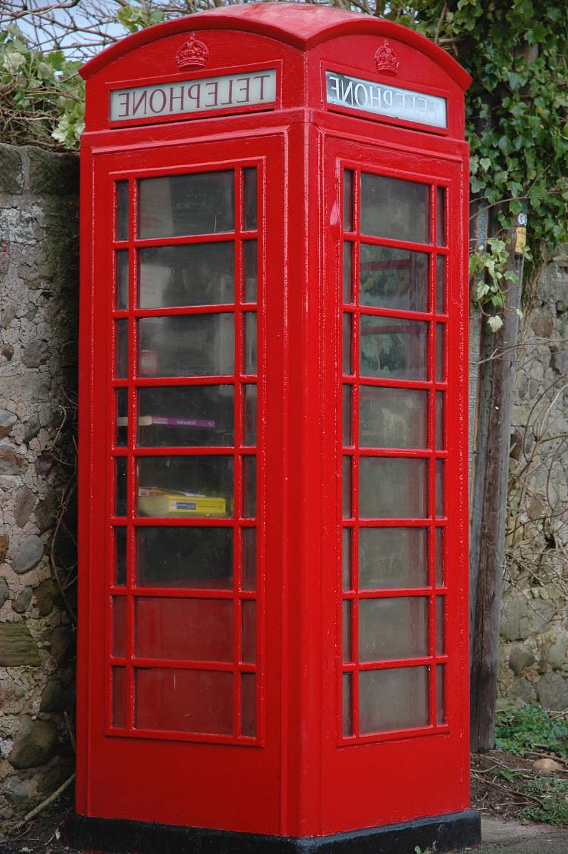 phone booth red wooden telephone booth beside gray concrete stonewall at daytime telephone
